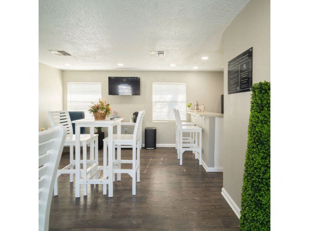 a room with a table and chairs and a tv on the wall