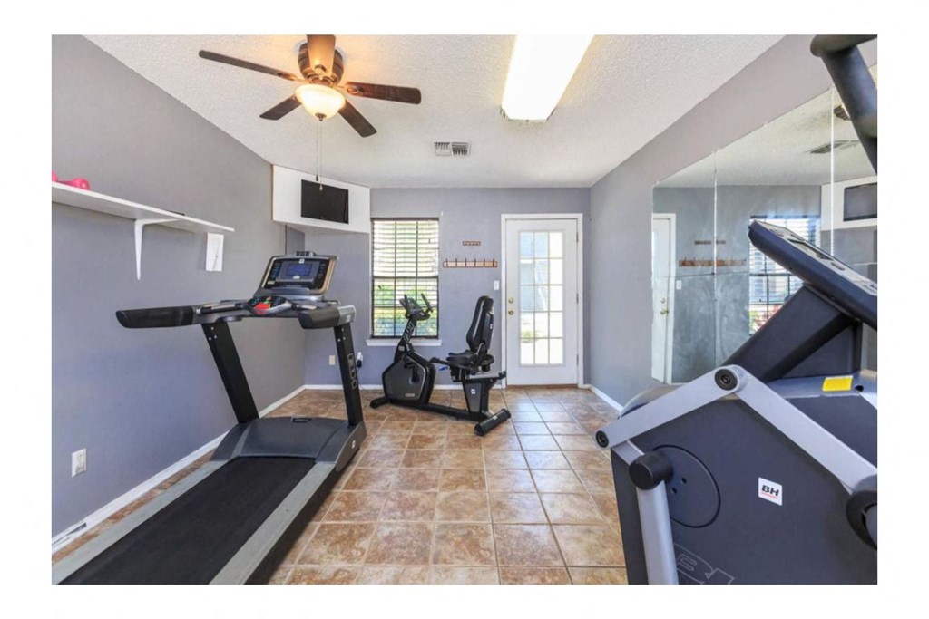 a home gym with two treadmills and a treadmill