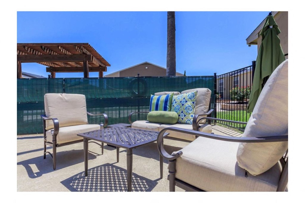 a patio with two chairs and a coffee table