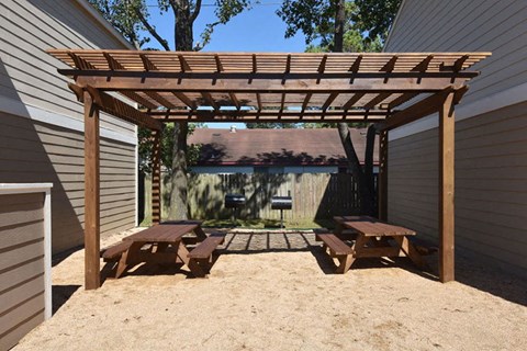 a pergola with benches in a backyard