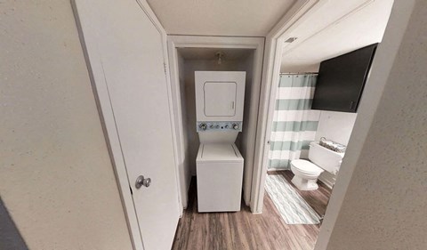 a small bathroom with a toilet and a washer and dryer