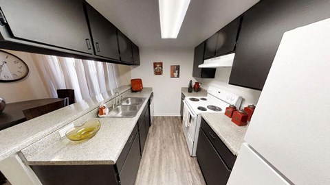 a small kitchen with black cabinets and white appliances