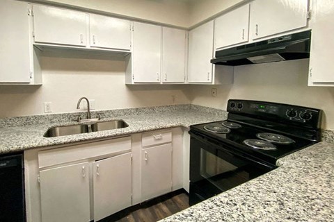 a kitchen with white cabinets and a black stove top oven