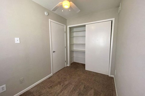 a bedroom with a closet and a ceiling fan