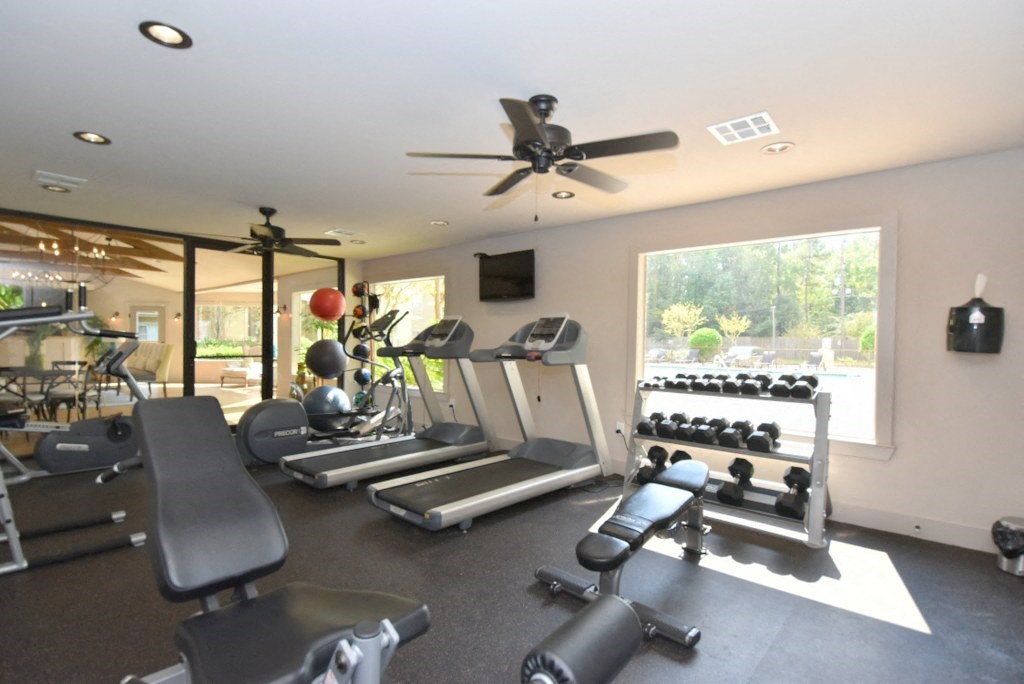 a room with a lot of exercise equipment and a large window