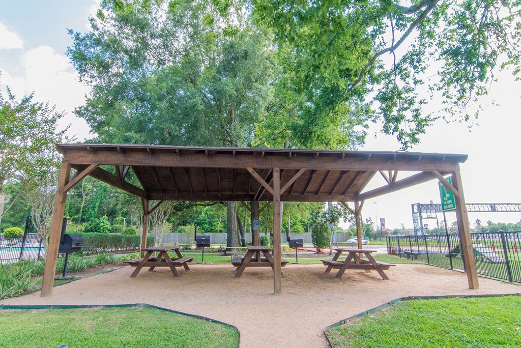 a picnic shelter with benches in a park