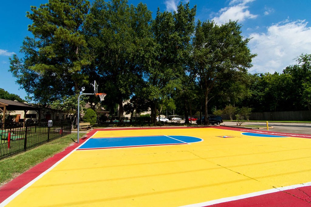 a basketball court with trees in the background