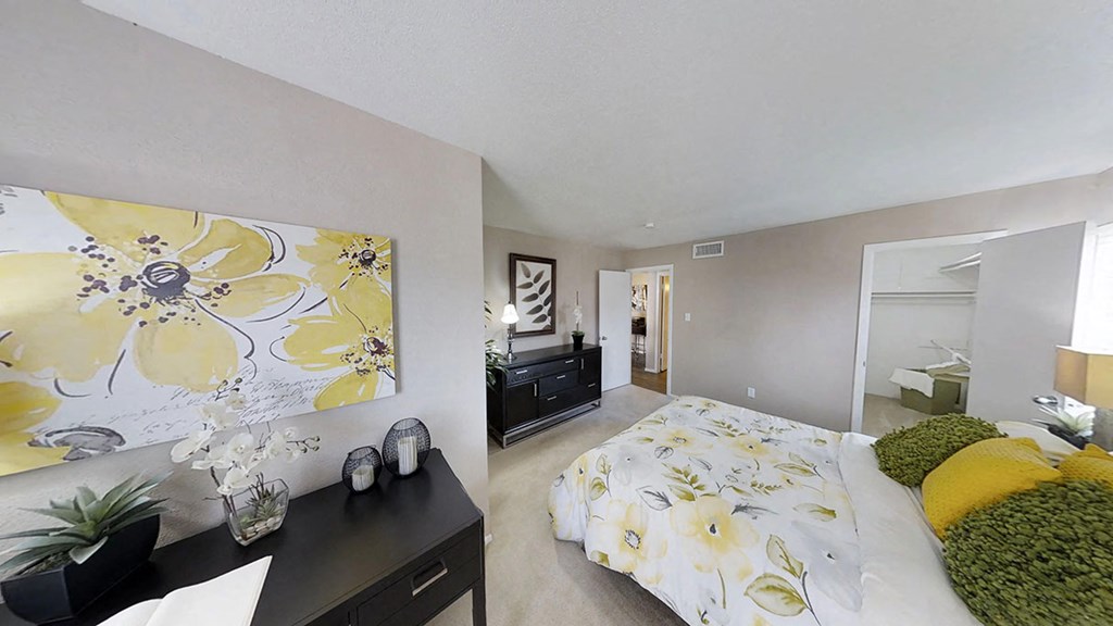 a bedroom with a large yellow and white painting on the wall