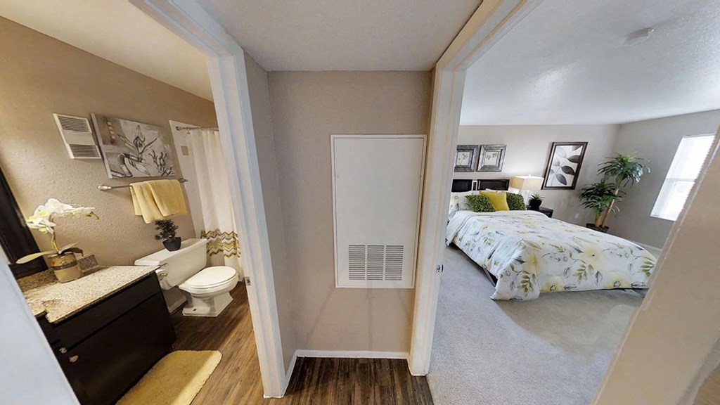 a bedroom with a bed and a bathroom with a toilet and sink