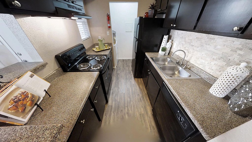 a kitchen with black cabinets and granite countertops