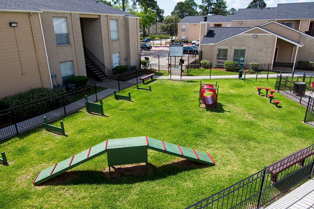 a park with a seesaw and benches in front of a building