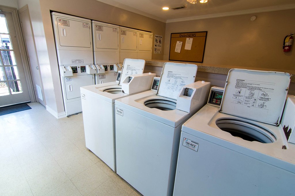 a laundry room with four washers and two dryers