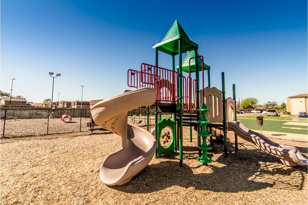 a playground with two slides and a climbing structure