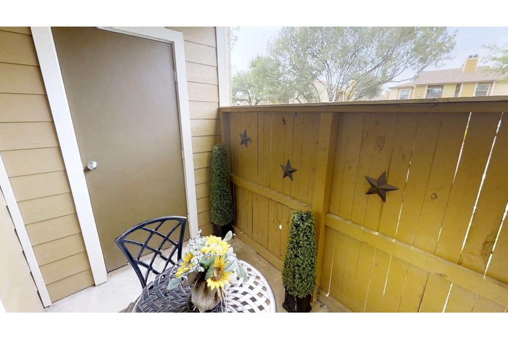 a patio with a table and chairs and a door with two stars on it