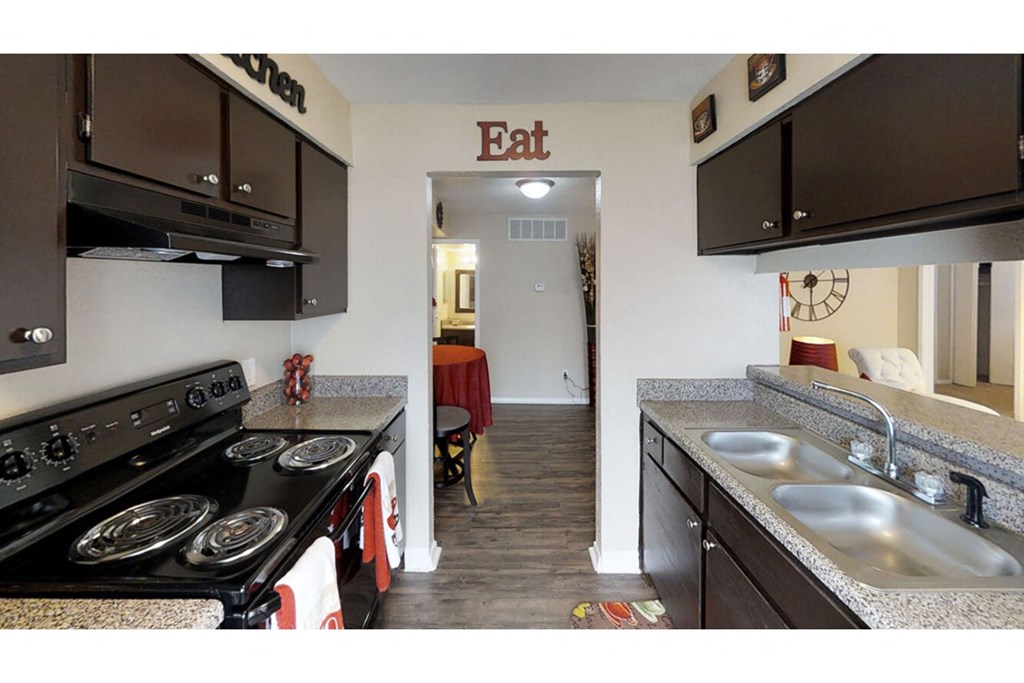 a kitchen with a stove top oven next to a sink