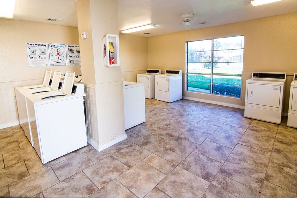 an empty laundry room with washers and dryers