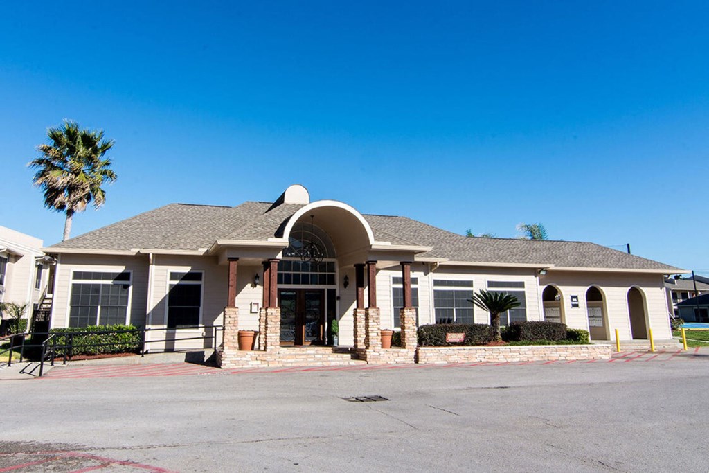 a large white building with a palm tree in the background