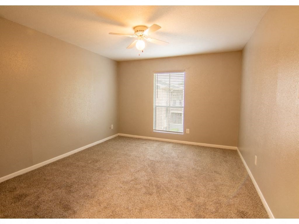 a bedroom with a ceiling fan and a window