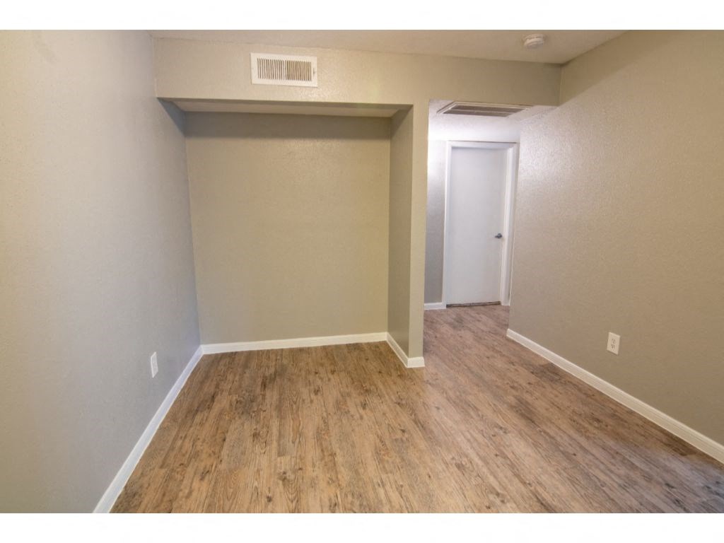 a bedroom with hardwood floors and grey walls