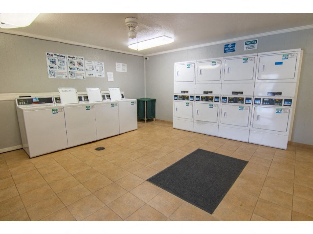 a laundry room with many washers and dryers