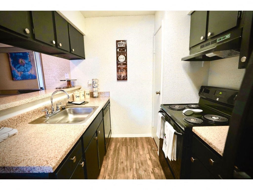a kitchen with a stove top oven next to a sink