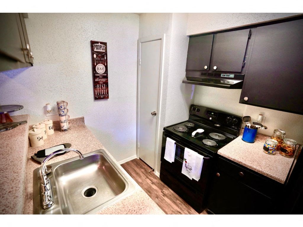 a kitchen with a stove top oven next to a sink