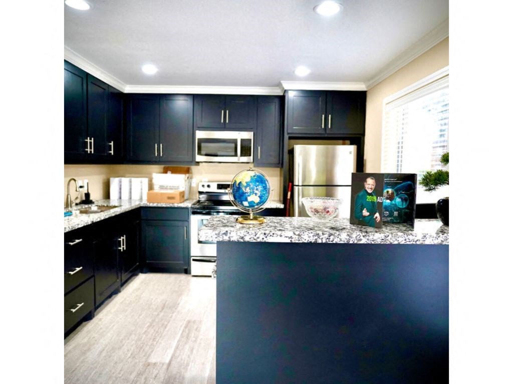 a kitchen with black cabinets and a globe on the counter