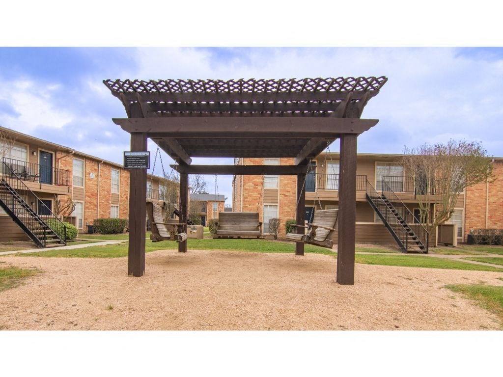 a pergola in front of a brick building