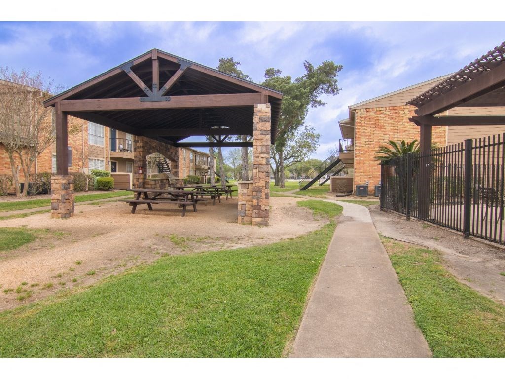 a picnic area with a table and benches in front of a building