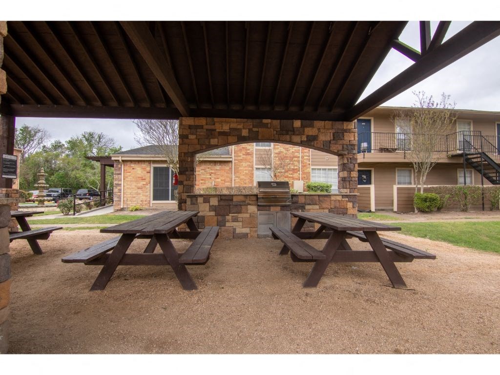 a picnic table with a grill in front of an apartment building