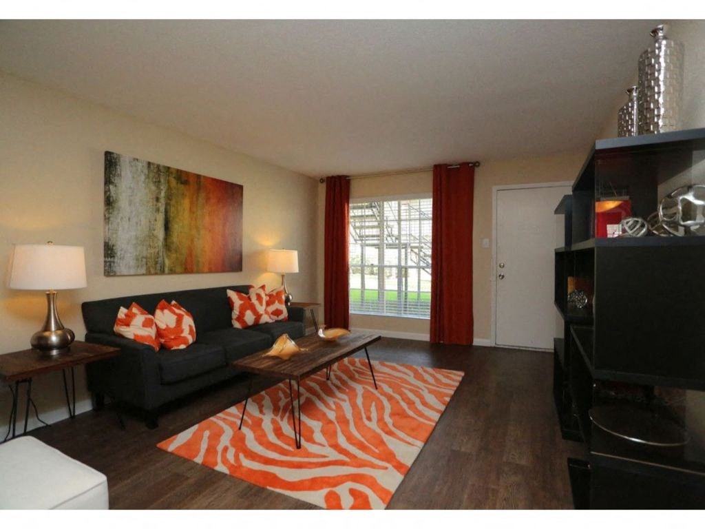 a living room with a black couch and a zebra rug