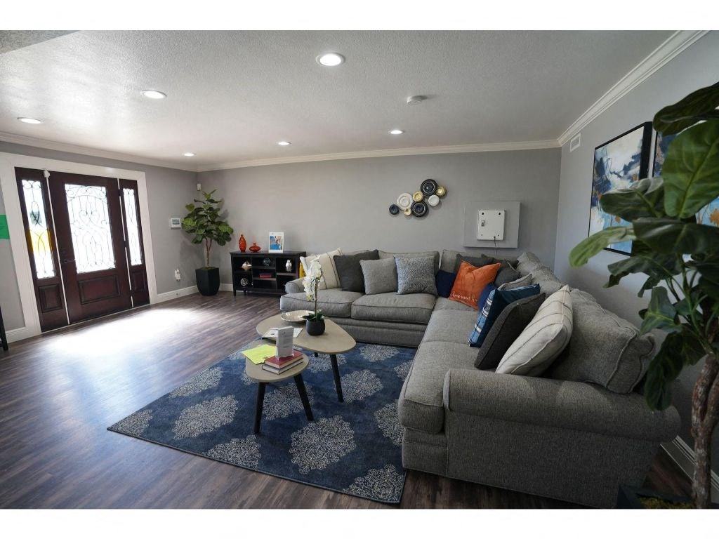 a living room with grey couches and a blue rug