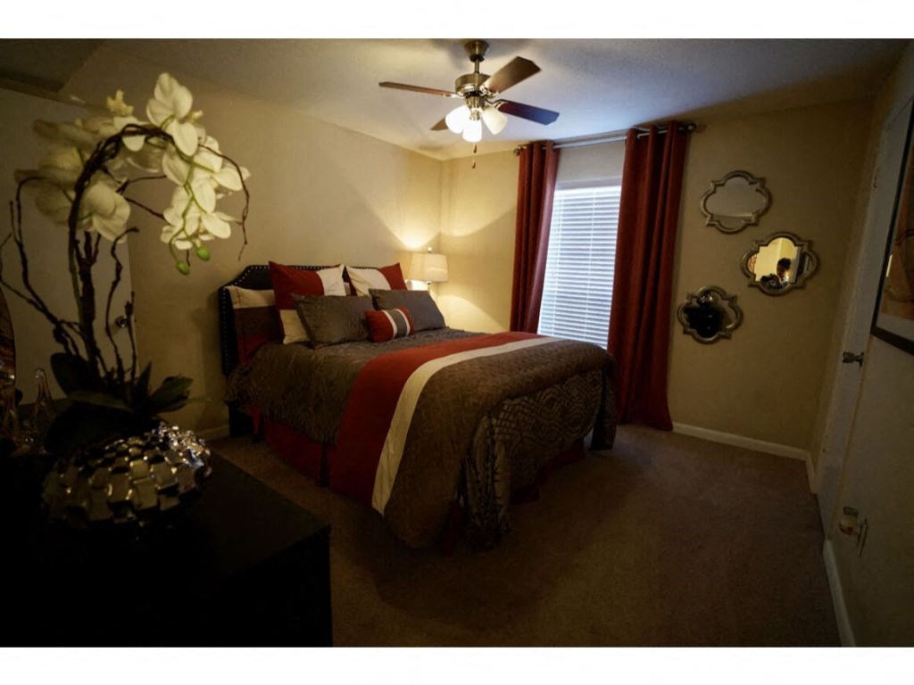 a bedroom with a bed and a ceiling fan