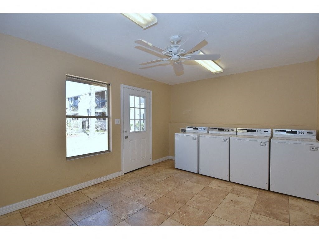 a laundry room with two washers and two dryers