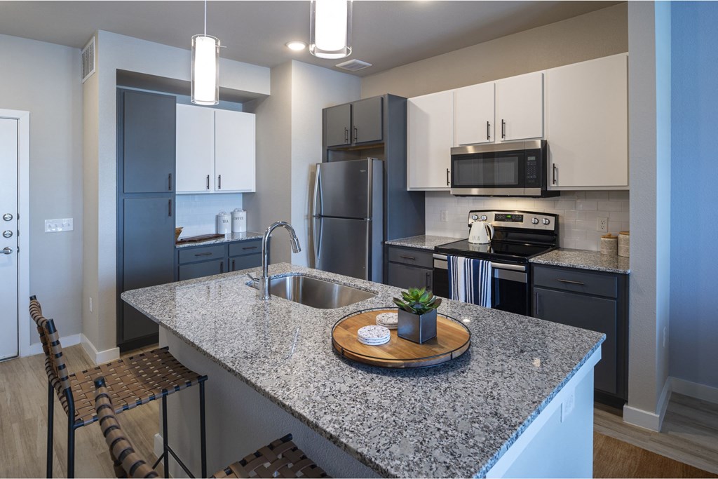 a kitchen with granite countertops and stainless steel appliances