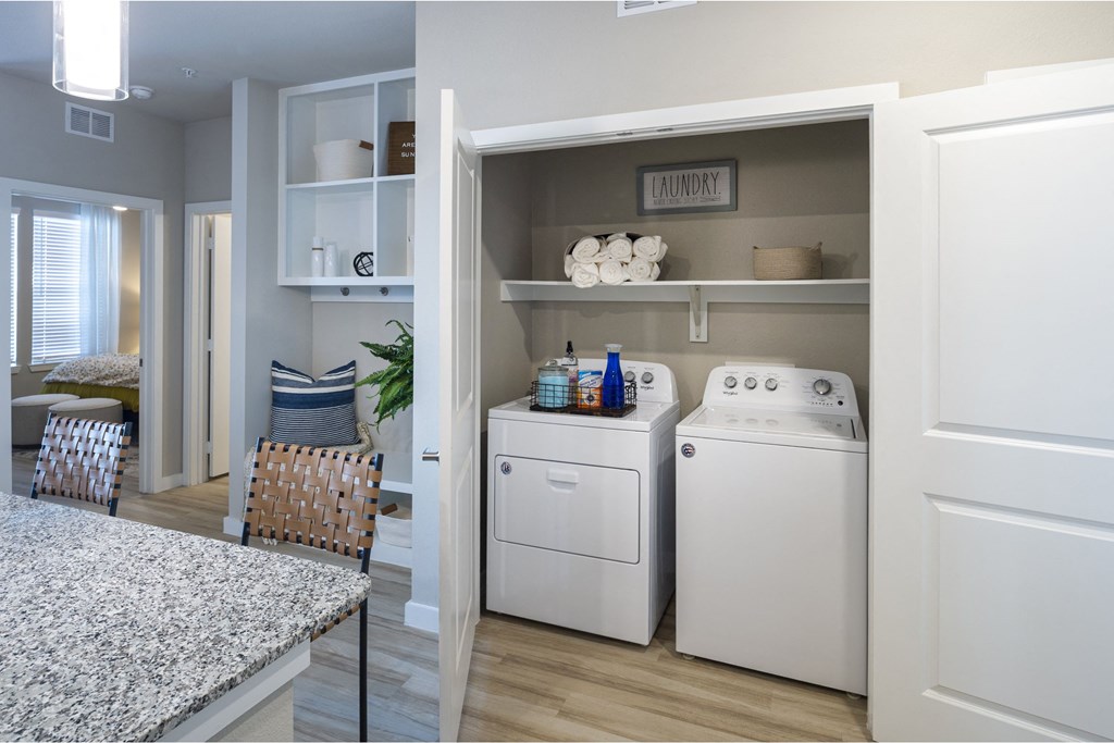 a kitchen with a washer and dryer and a table and chairs