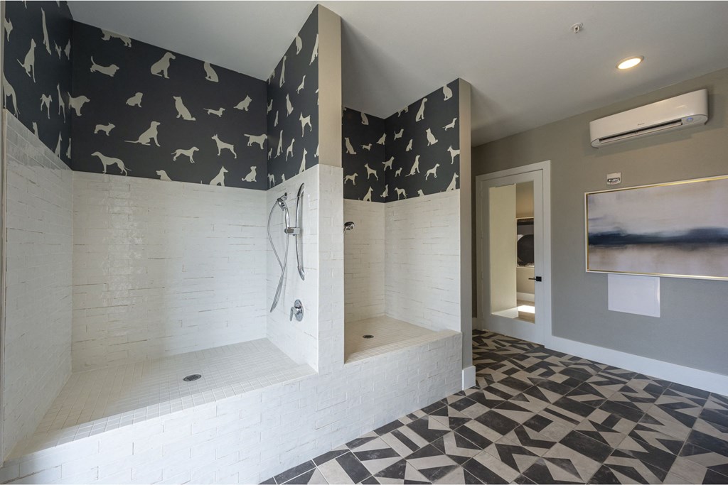 a large bathroom with black and white tile flooring and a large shower with a shower head