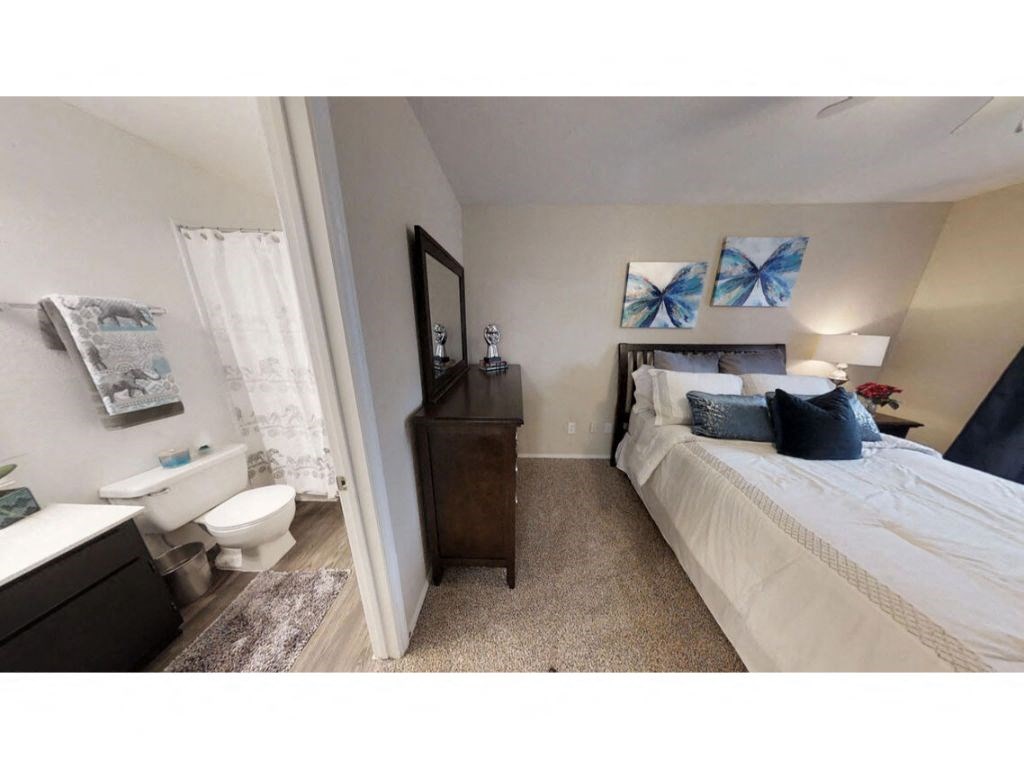 a bedroom with a bed and a toilet in a room