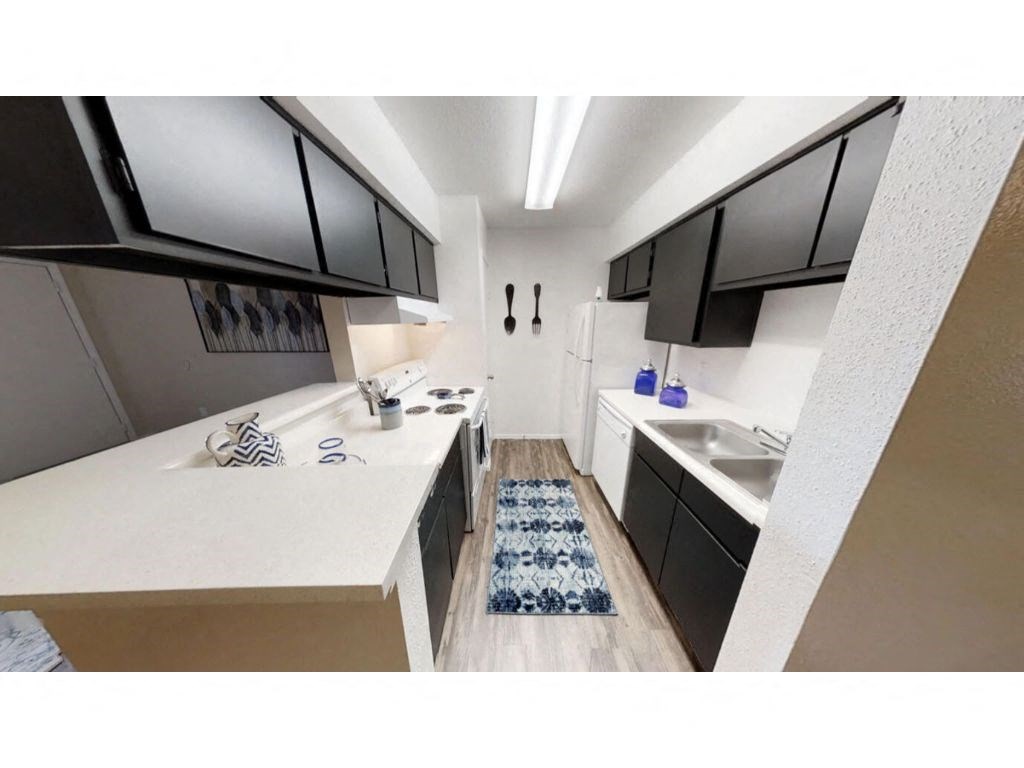 a kitchen with black cabinets and a white counter top