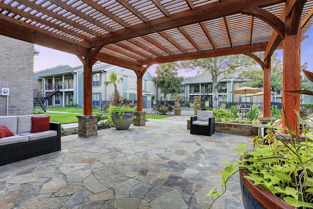 a wooden pergola with a stone patio