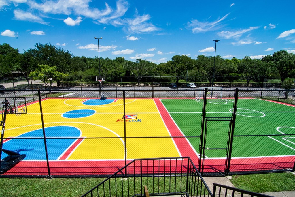 a view of the lacrosse field with a blue sky and trees in the background