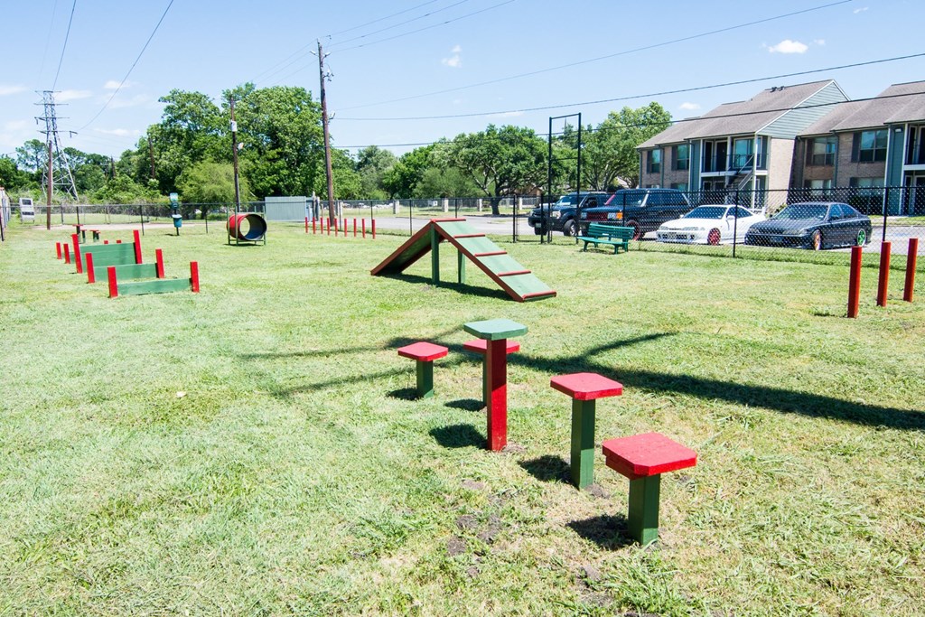 a picnic table and benches sit in the middle of a grassy area with a seesaw
