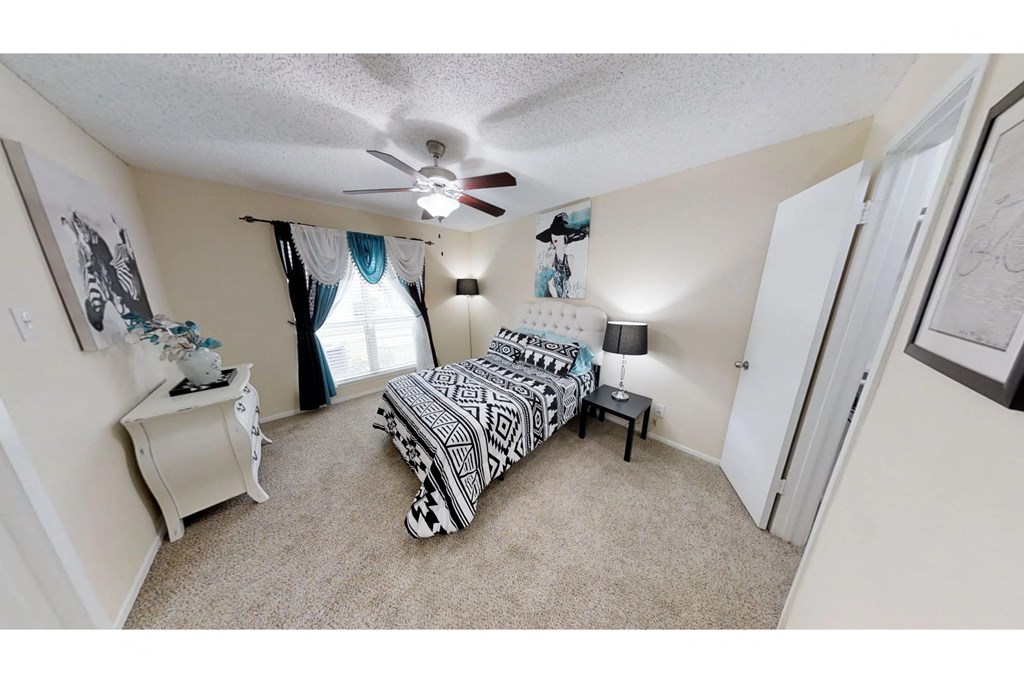 a bedroom with a bed and a ceiling fan