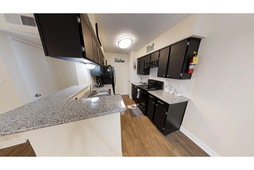 a kitchen with black cabinets and a white counter top