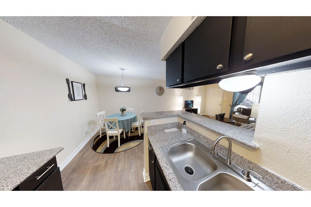 a kitchen with a sink and a table with a chair