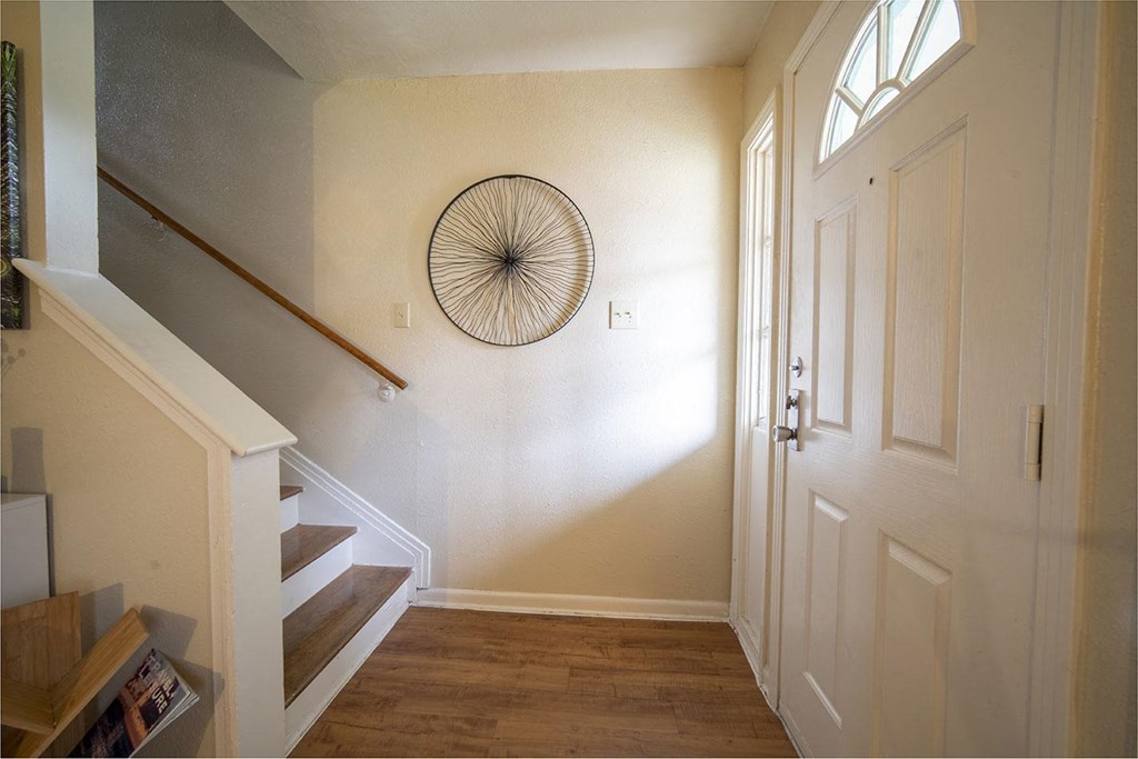 a view of the entryway of a house with a round mirror on the wall