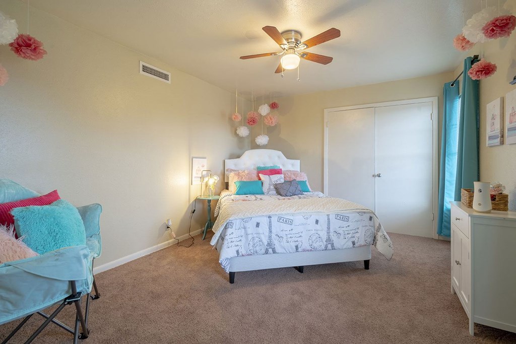 a bedroom with a bed and a ceiling fan