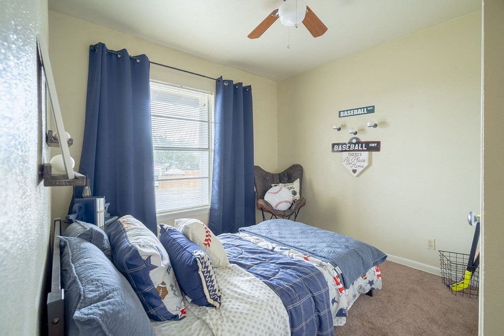 a bedroom with two beds and a ceiling fan