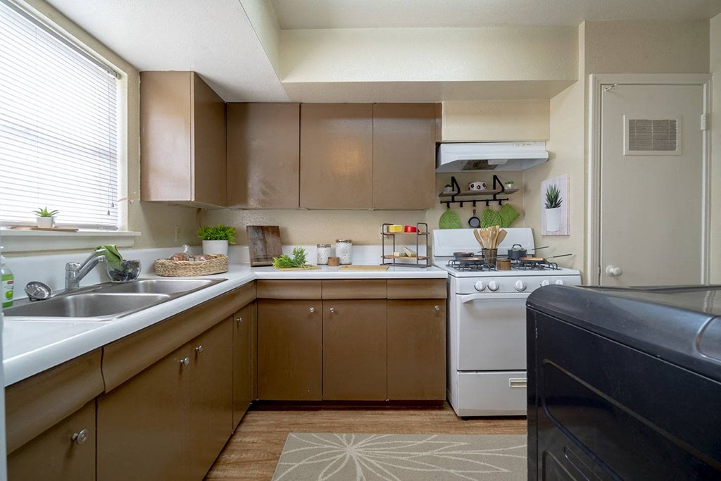 a kitchen with a white stove top oven next to a sink