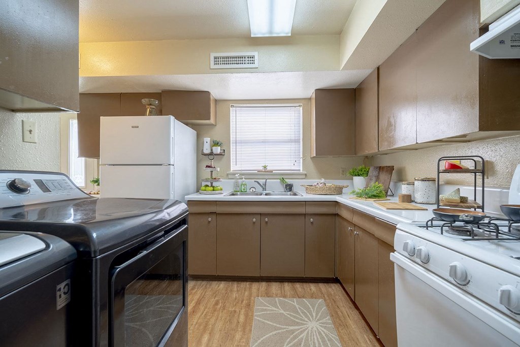 a kitchen with white appliances and brown cabinets